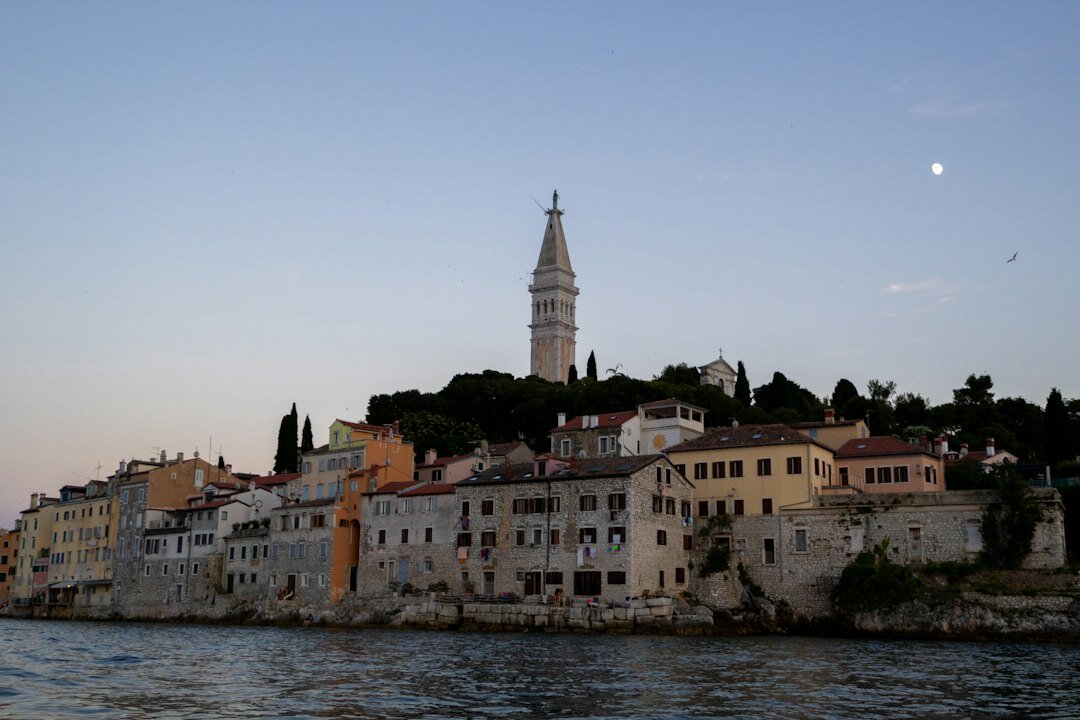 Old stone lighthouse on Adriatic coast at dusk