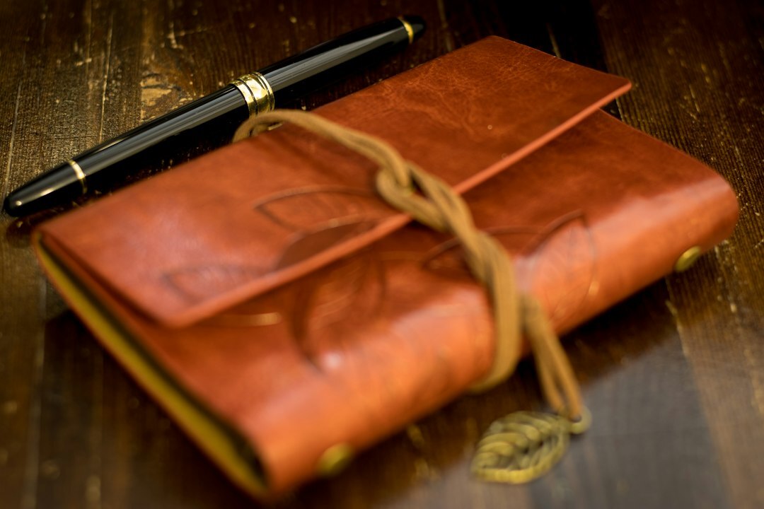 Old leather bound notebook with fountain pen and key