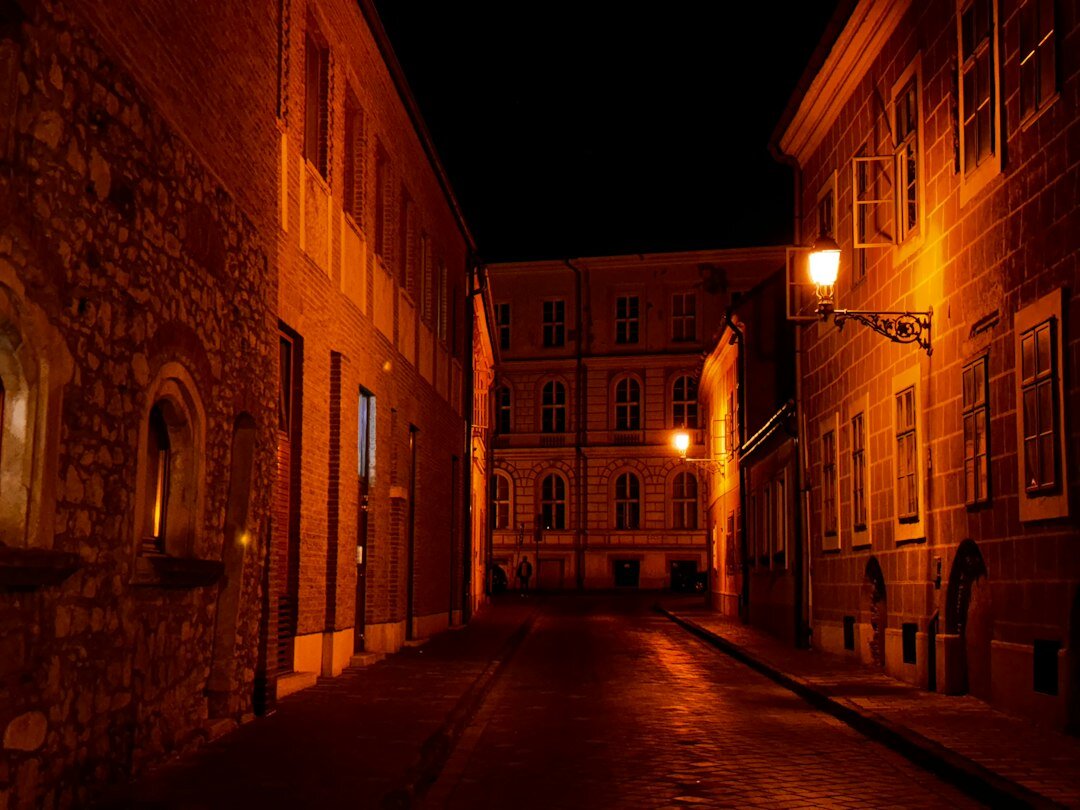 Foggy cobblestone street in an old European town at night